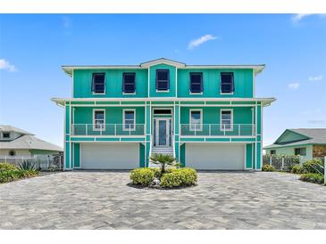 Two-story teal home with a three-car garage and paver driveway at 4711 S Atlantic Ave, Ponce Inlet, FL 32127