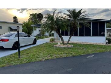 Single-wide mobile home with carport and nicely landscaped yard at 216 Rue De Paresse, Tavares, FL 32778
