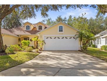 Beautiful yellow house with white garage door and landscaping at 1113 Athlone Way, Ormond Beach, FL 32174