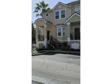 Townhouse with balconies, stairs, and a paved driveway at 6550 Time Square Ave # 105, Orlando, FL 32835