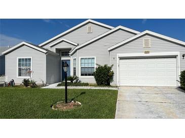 Gray vinyl sided home with 2 car garage at 25331 Hibiscus St, Leesburg, FL 34748