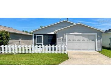 Gray exterior home with attached garage and a small front yard at 17463 Se 81St Newberry Ct, The Villages, FL 32162