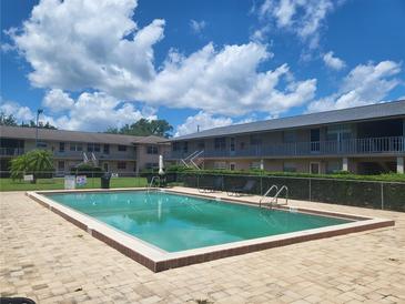 Relaxing community pool with plenty of lounge chairs and a fenced area at 1100 E Caroline St # 115, Tavares, FL 32778