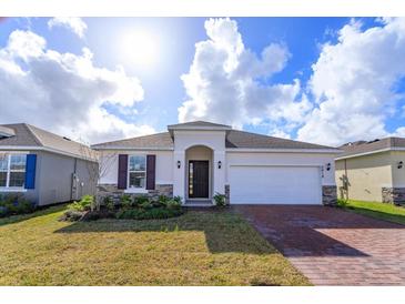 Single-story home with brick driveway and landscaping at 5818 Camilla St, Saint Cloud, FL 34771