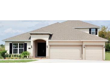 Two-story house with beige exterior, three-car garage, and landscaping at 2368 Juniper Berry Dr, Minneola, FL 34715