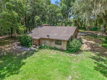Rustic one-story home on a spacious lot with lush trees at 2027 Cr 232, Wildwood, FL 34785
