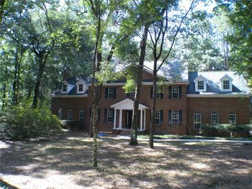 Brick house with large trees and a green lawn at 415 Se 123Rd Street Rd, Ocala, FL 34480