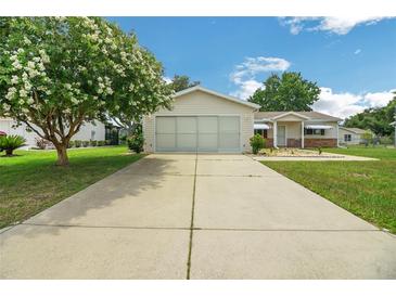 Single-story home with a two-car garage and landscaped yard at 17548 Se 96Th Ave, Summerfield, FL 34491