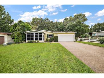 Charming single-story home with attached garage and lush lawn at 25043 Bellevue, Leesburg, FL 34748