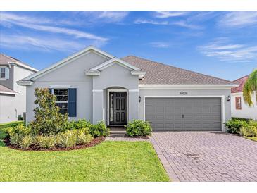 Two-story house with gray siding and navy shutters at 30025 Island Club Dr, Tavares, FL 32778