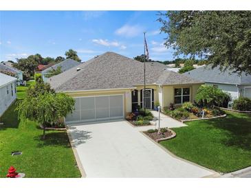 One-story home with a two-car garage and well-maintained landscaping at 1914 Iglesia St, The Villages, FL 32159