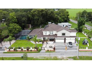 Two story house with pool, lush landscaping, and large driveway at 1304 Ocoee Apopka Rd, Ocoee, FL 34761