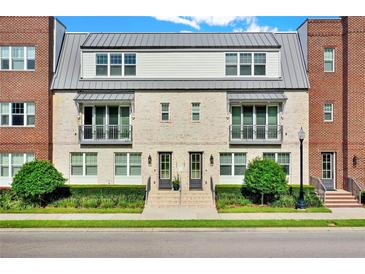 Two-story townhome with brick facade, metal roof, and landscaping at 137 S Park Ave, Winter Garden, FL 34787