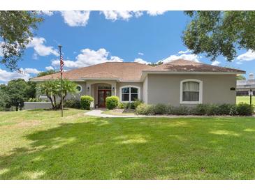 One-story home with a red door and manicured lawn at 5515 Citation Ct, Lady Lake, FL 32159