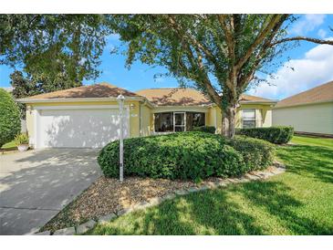 Charming house exterior with mature landscaping and driveway at 1213 El Esparza Ln, The Villages, FL 32159