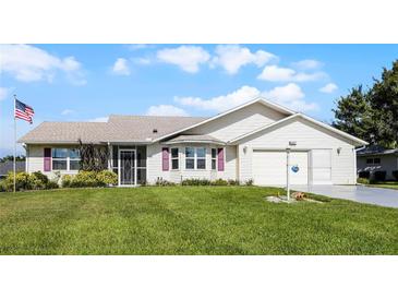 House exterior featuring a two-car garage and manicured lawn at 6401 Tildon, Leesburg, FL 34748