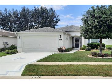 Single-story home with a two-car garage and landscaped yard at 16360 Sw 15Th Ct, Ocala, FL 34473