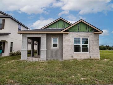 Newly constructed single-story home with block exterior and covered porch at 10593 Grand Oaks Blvd, Oxford, FL 34484