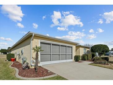 Attached garage with a screened enclosure, and landscaping at 15300 Sw 14Th Avenue Rd, Ocala, FL 34473