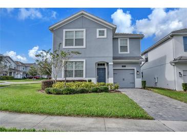 Two-story house with gray siding and a two-car garage at 1592 Flange Dr, Davenport, FL 33896