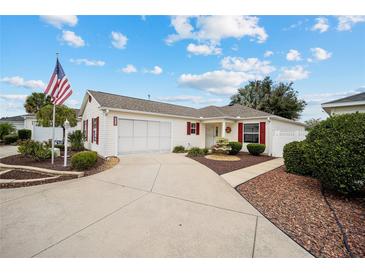 Single-story home with a two-car garage and landscaped yard at 8457 Se 177Th Penman Pl, The Villages, FL 32162