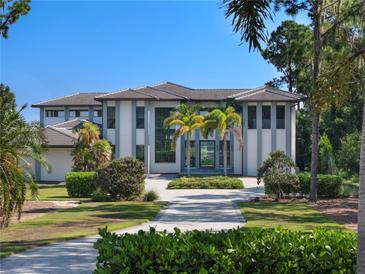 Modern two-story home with gray and white exterior, and palm trees at 15617 Pendio Dr, Bella Collina, FL 34756