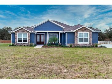 New construction home features stone accents and a welcoming front porch at 38530 Wooded Meadow Drive, Umatilla, FL 32784