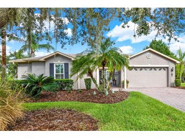 Single story home with landscaping, palm trees, and a two car garage at 1238 Glendora Rd, Kissimmee, FL 34759