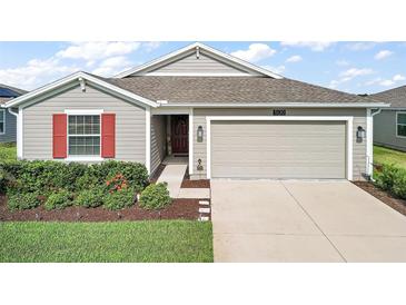 Single-story home with gray siding, red shutters, and a two-car garage at 5120 Tanzanite Dr, Mount Dora, FL 32757