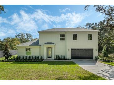 Two-story Craftsman home features a neutral exterior, two-car garage, and manicured lawn at 12332 Basin St, Clermont, FL 34715