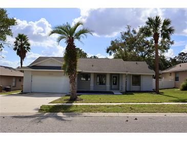 Updated single story home with a gray exterior, white accents and a neatly landscaped lawn at 15622 Hidden Lake Cir, Clermont, FL 34711