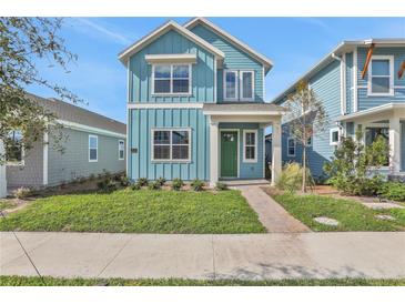 Two-story light blue house with green door, landscaping, and walkway at 3018 Mirage Pl, St Cloud, FL 34771