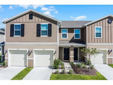 Two-story townhome with attached garages and landscaping at 1496 Mirabella Cir, Davenport, FL 33897