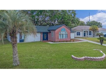 Charming one-story home with brick facade and well-maintained landscaping at 307 Water Shore Dr, Leesburg, FL 34748