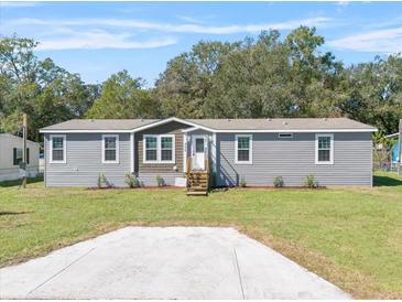 Single-Gathering home with gray siding, landscaping and driveway at 18451 14Th Ave, Orlando, FL 32833