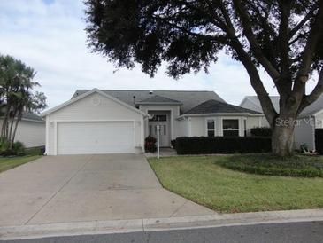 One-story house with two-car garage and landscaped yard at 3425 Dixon Ln, The Villages, FL 32162