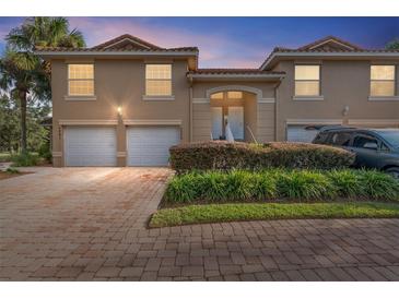 Townhouse exterior with two-car garage and landscaped entryway at 5279 Bowline Ct, Oxford, FL 34484