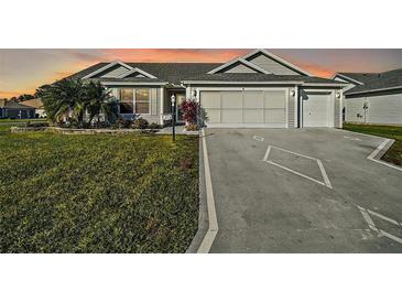 Two-car garage and landscaped lawn at 1711 Augustine Dr, The Villages, FL 32159