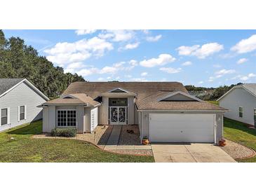 Single-story house with attached garage and landscaped yard at 25114 Meriweather Rd, Leesburg, FL 34748