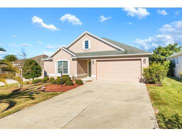 One-story house with a two-car garage and landscaped yard at 1429 Bluebeard Ct, The Villages, FL 32163