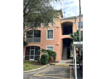 Two-story condo building with balconies and a staircase leading to upper units at 13584 Turtle Marsh Loop # 132, Orlando, FL 32837