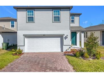Two-story house with gray siding, white garage door, and landscaping at 30224 Armenia Rd, Leesburg, FL 34748