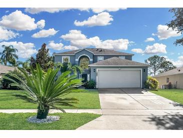Two-story house with a gray exterior, white garage door, and landscaping at 1087 Welch Hill Cir, Apopka, FL 32712