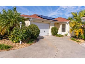 Bright, charming house with solar panels and well-manicured landscaping at 1442 Almanza Dr, The Villages, FL 32159