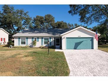 House exterior featuring a teal garage door and a landscaped front yard at 4800 Tara View Rd, Leesburg, FL 34748