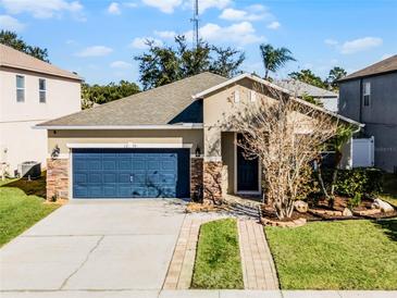 One-story home with a two-car garage and landscaped front yard at 1239 Alapaha Ln, Orlando, FL 32828