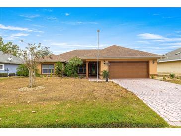 One-story home with brown garage door and landscaped yard at 17329 Se 115Th Terrace Rd, Summerfield, FL 34491