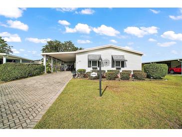 Charming single-story home with a paved driveway and landscaped yard at 1715 Lilly Ln, Lady Lake, FL 32159