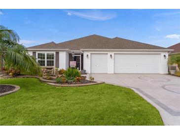 White house with three-car garage, landscaping, and circular driveway at 4318 St Stephen St, The Villages, FL 32163