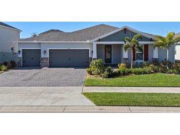 Two-story home with gray siding, red accents, and a lush lawn at 771 Annabell Ridge Rd, Minneola, FL 34715